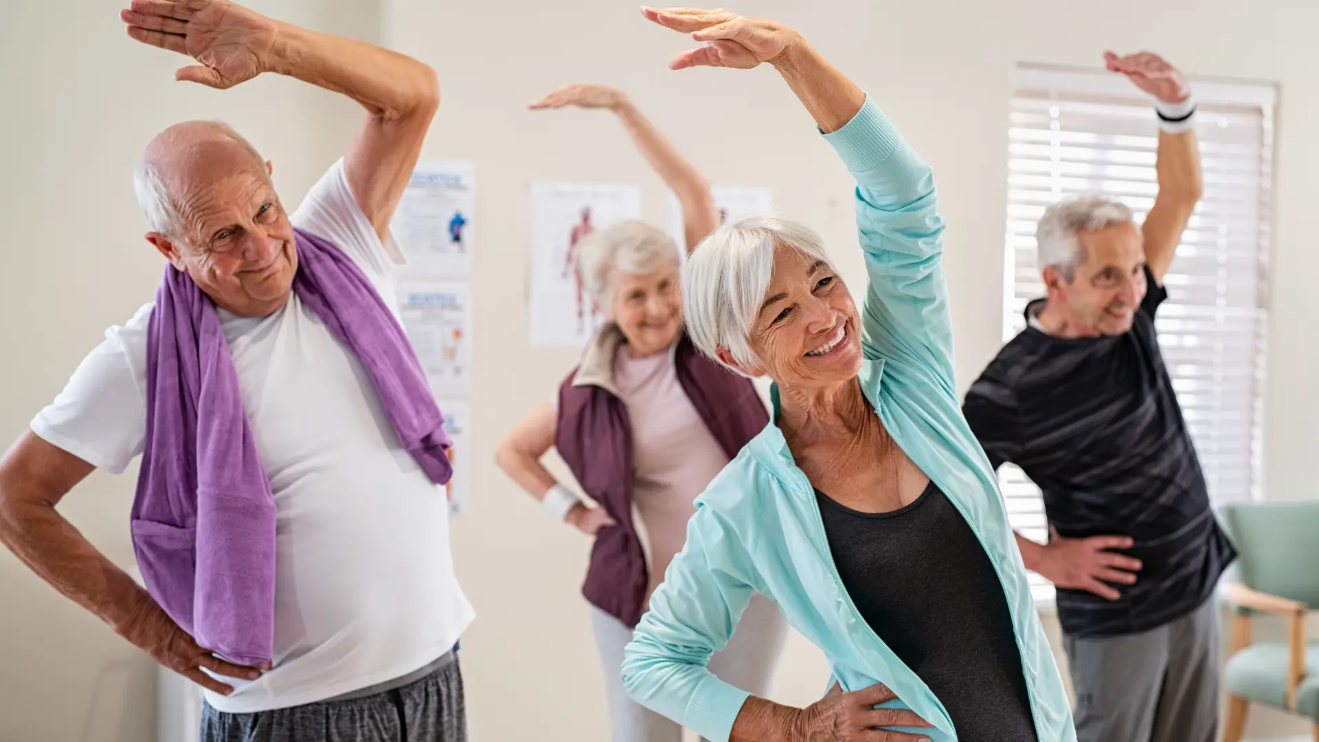 Four older adults enjoying a gentle group stretching class.